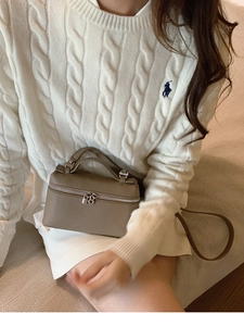 Detail der khakifarbenen Lederbox-Tasche mit Silberbeschlägen am Model-Outfit