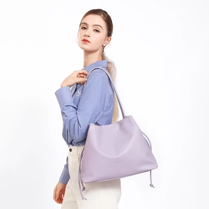 Lavendelviolette Beuteltasche aus weichem Leder mit Kordelzug am Model gezeigt