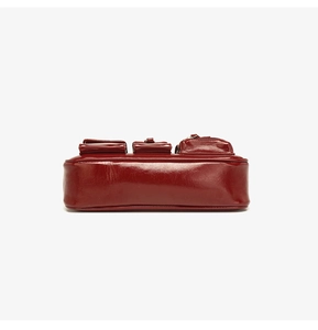 Makro-Unteransicht der dunkelroten glänzenden Ledertasche mit funktionellen Taschen