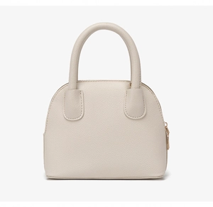 Macro detail of high-quality lychee pattern leather texture on beige shell handbag