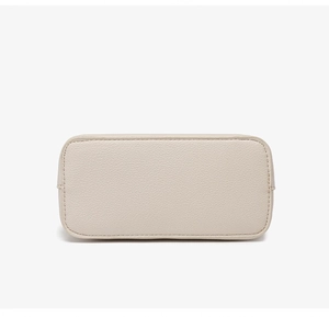 Detail of the high-quality lychee grain leather bottom with precise stitching on a beige bag