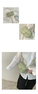 Close-up of mint green V-quilted leather bag with gold chain strap and heart charm