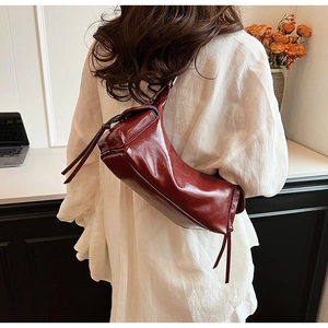 Detailed view of vintage burgundy leather shoulder bag with decorative zipper accents