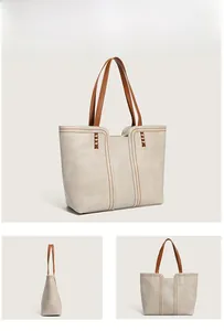 Detail view of large tote bag with contrast brown straps and refined stitching accents