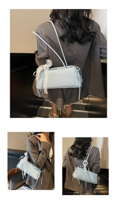 Detail view of light blue baguette bag with white lace trim and slim double straps