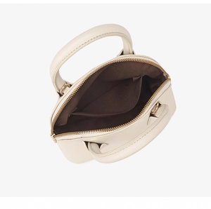 Detailed interior view of a beige shell bag with dark brown lining and gold zipper