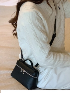 Detailansicht einer schwarzen Mini-Tasche aus Narbenleder mit silbernen Beschlägen
