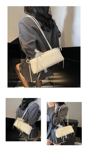 Close-up of white rectangular baguette bag with delicate lace trim and ribbon bow detail