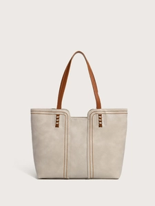 Detailed view of beige faux leather tote bag with lychee texture and woven stitching