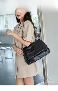 Detail view of large black chain shoulder bag on model for daily commuting style