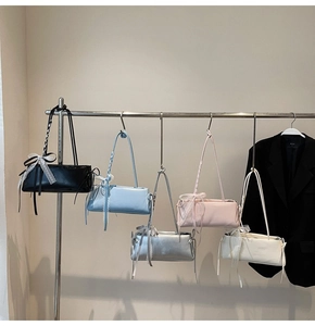 Close-up of baguette underarm bags in multiple colors with delicate lace bow details