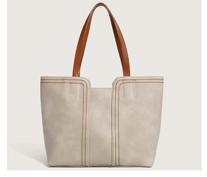 Detail of off-white tote bag featuring brown contrast stitching and premium faux leather texture