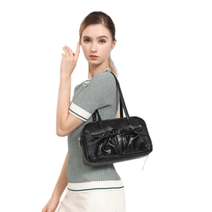 Klassische schwarze Bowlingtasche mit plissierten Schleifentaschen am Model getragen