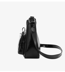Detail view of glossy black faux leather crossbody bag with transparent front card pocket
