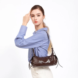 Glossy dark brown faux leather shoulder bag featuring side drawstrings and minimalist design
