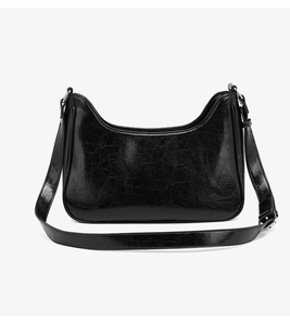 Detail of glossy black crossbody bag with pleated texture and adjustable strap