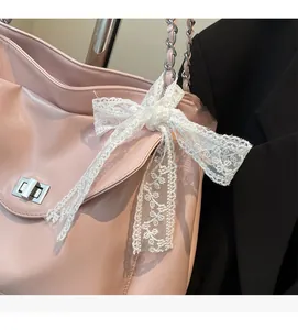 Detailed shot of pink faux leather bag with lace bow and silver twist lock closure