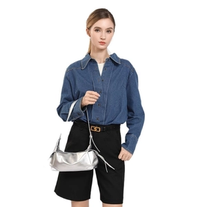 Silberne Schultertasche mit langen Fransen am Modell vor weißem Hintergrund präsentiert