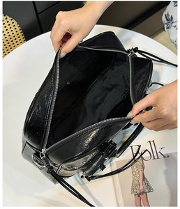 Top view of spacious black leather tote interior showing silver zippers and large main pocket