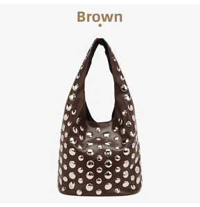 Detailed view of a brown leather Hobo bag featuring silver metal star-patterned rivets