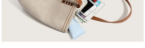Detail of off-white tote bag showing large capacity for tablet and daily items