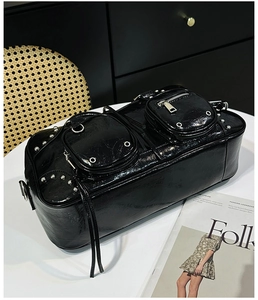 Detail of black biker style tote with silver studs and polished oil wax leather texture