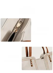 Detail of premium gold hardware zipper and contrast stitching on ivory tote bag