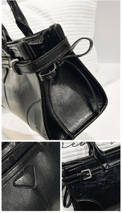 Detail einer schwarzen glänzenden Ledertasche mit dekorativer Schleife und Logo-Patch
