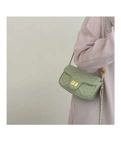 Detail of light green mint crossbody bag with chevron quilting and golden chain strap