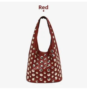 Detail view of burgundy red hobo bag featuring dense silver stud rivets and matte leather