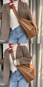 Detail view of large brown soft leather tote bag with wide strap and relaxed drape