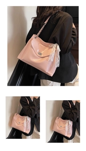 Pink PU leather tote bag with lace bow and metal twist lock detail close-up