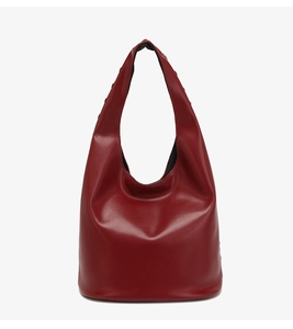 Detail view of smooth wine red leather texture and minimalist hobo bag construction