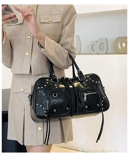 Close-up of black patent leather bag featuring silver metal studs and long fringe details