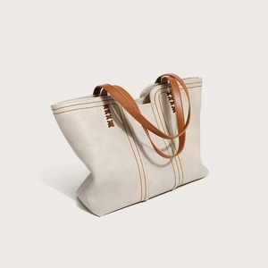 Minimalist beige tote bag with brown handles and decorative cross stitching details