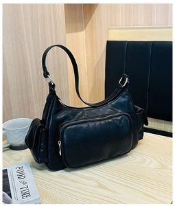Close-up of black retro hobo bag with front zip pocket and silver metal hardware