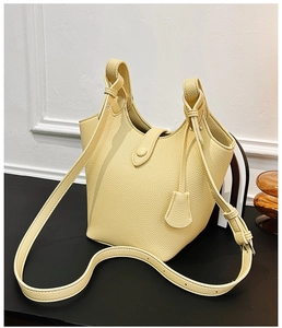 Detail der hellgelben Eimer-Tasche aus Leder mit Litschi-Muster und Trageriemen