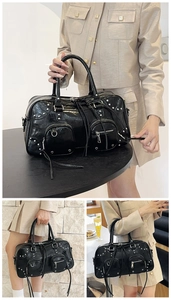Detail of black faux leather tote with silver studs, long tassels and front zip pockets