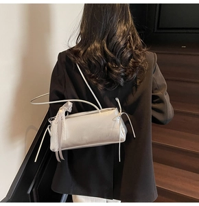 Detail of silver metallic baguette bag with lace bows and ribbons in a chic interior setting