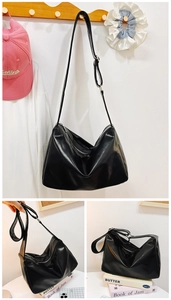 Detail view of black soft faux leather hobo bag with adjustable wide shoulder strap