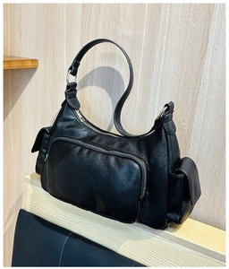 Detail of vintage black shoulder bag with textured faux leather and multiple zipper pockets