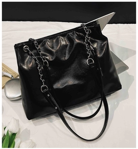 Vue détaillée du grand sac cabas noir avec chaînes argentées et texture froissée brillante