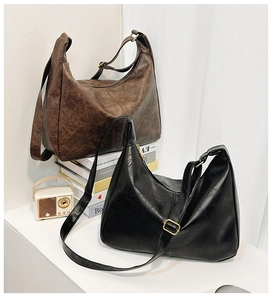 Détail de grands sacs fourre-tout vintage noir et marron avec grain de cuir et boucles dorées