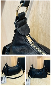 Close-up of litchi grain leather texture and golden metal hardware on black shoulder bag