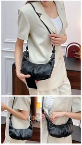 Detail of black croissant crescent bag showing pleated leather and knotted strap design