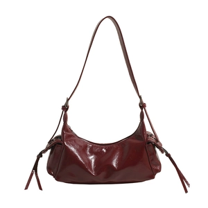 Detailed close-up of dark red glossy leather hobo bag with zipper tassel accents