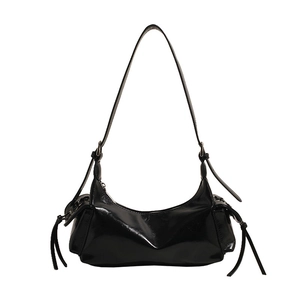 Detail of black glossy faux leather hobo bag with side tassel drawstring accents