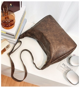 Vue détaillée d'un sac cabas marron foncé vintage avec texture cuir et boucles en laiton