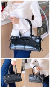 Detailansicht einer schwarzen glänzenden Schultertasche mit Dreieckspatch und Metallschnallen