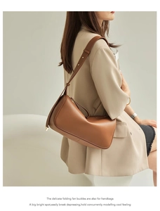 Close-up of caramel leather shoulder bag with adjustable strap and metallic hardware details
